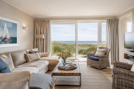Helles Wohnzimmer mit Rattanmöbeln und Panorama-Meerblick