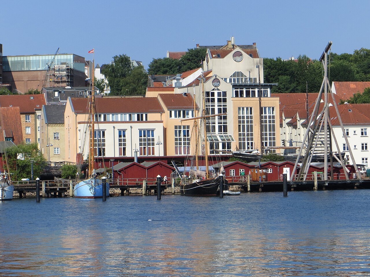 Historische Segelschiffe und rote Werftschuppen der Museumswerft am Flensburger Hafen