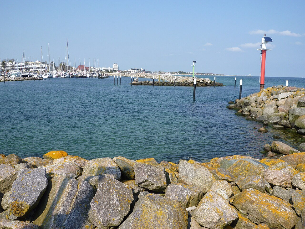 Hafeneinfahrt des Yachthafens Grömitz mit Steinmole, Booten und Ortssilhouette