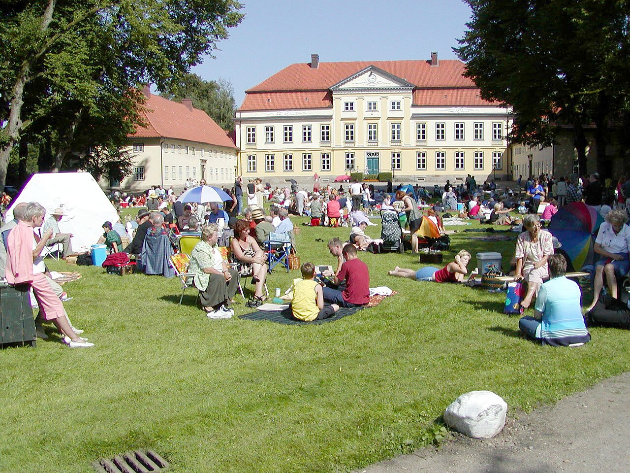 Picknickende Konzertbesucher auf der Wiese vor dem Herrenhaus Gut Emkendorf beim Schleswig-Holstein Musik Festival.