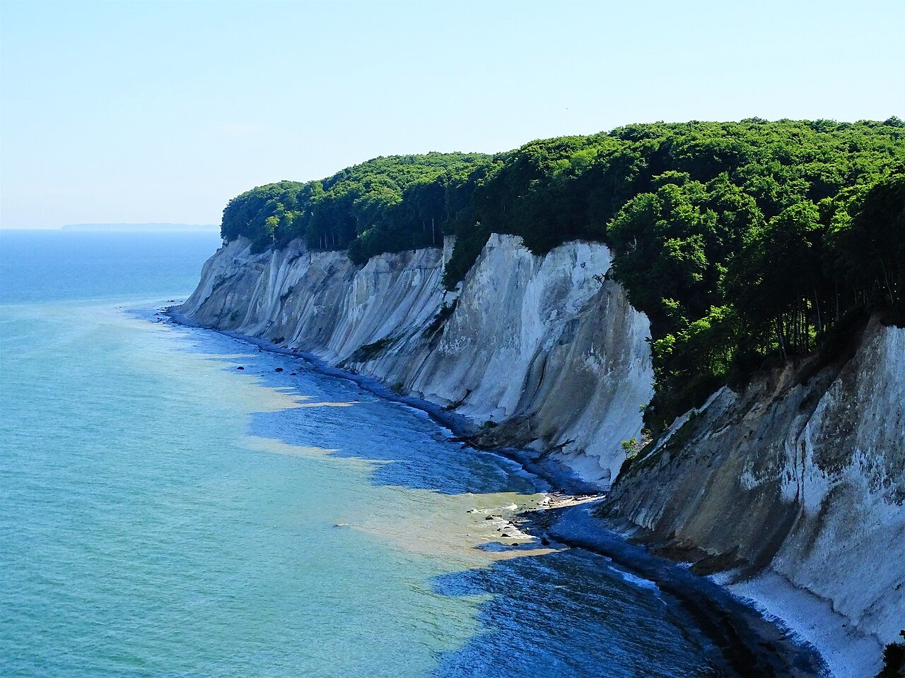 Kreidefelsen des Nationalparks Jasmund auf Rügen mit grünem Buchenwald und türkisblauer Ostsee